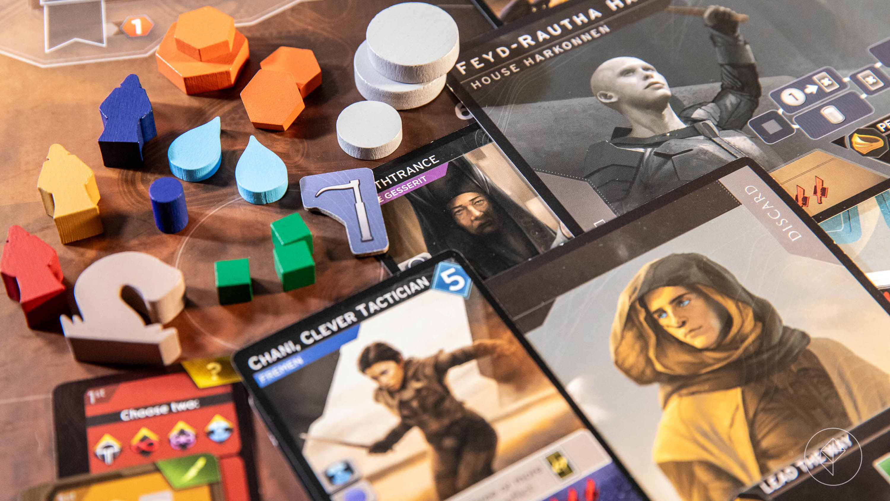 A collection of bits from Dune: Imperium - Uprising, including cards depicting Timothy and Zendaya, plus wooden water and spice tokens.