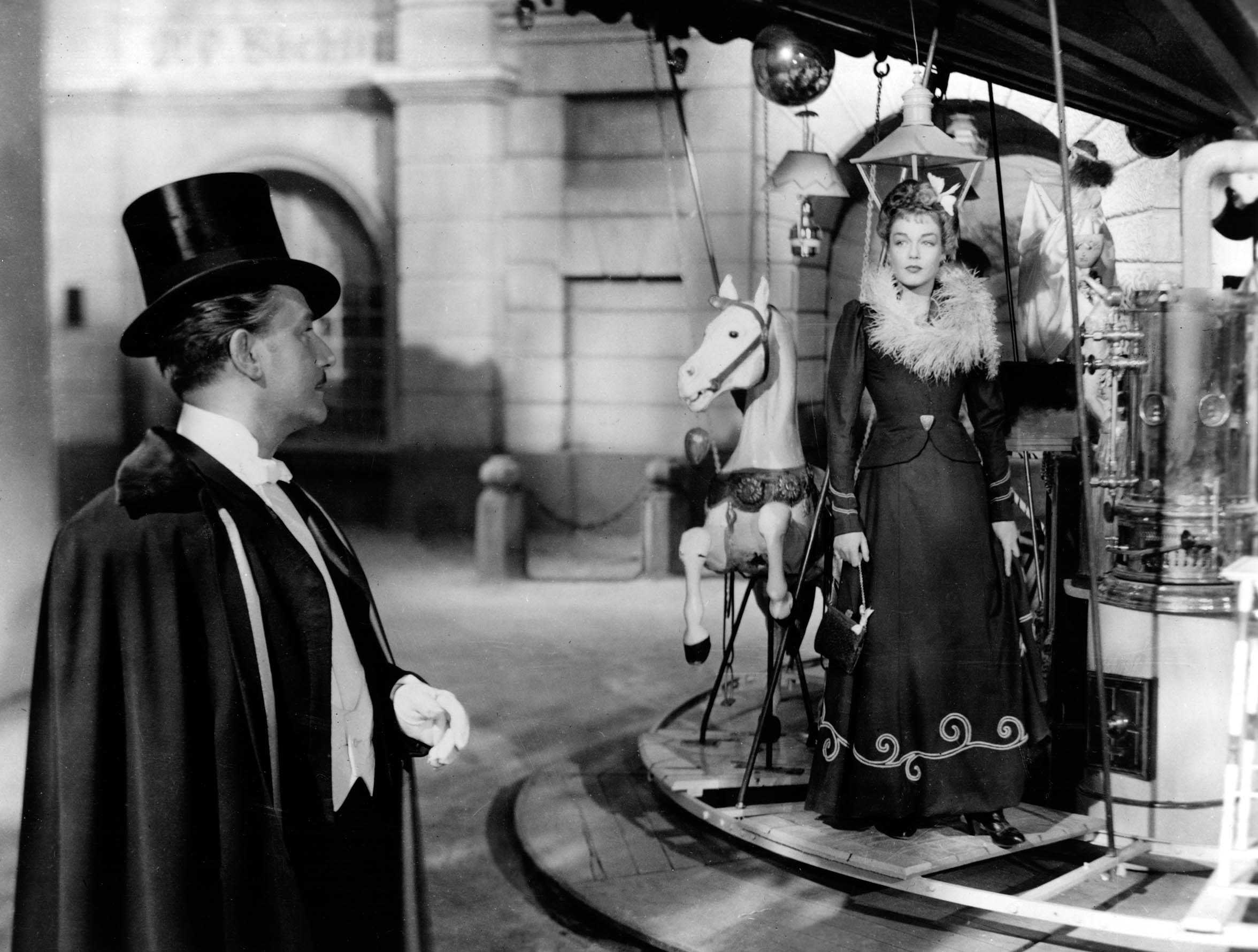Anton Walbrook looks at Simone Signoret, on a merry-go-round, in La Ronde